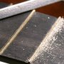 Filling and rounding of the leveled frets with a triangular file.